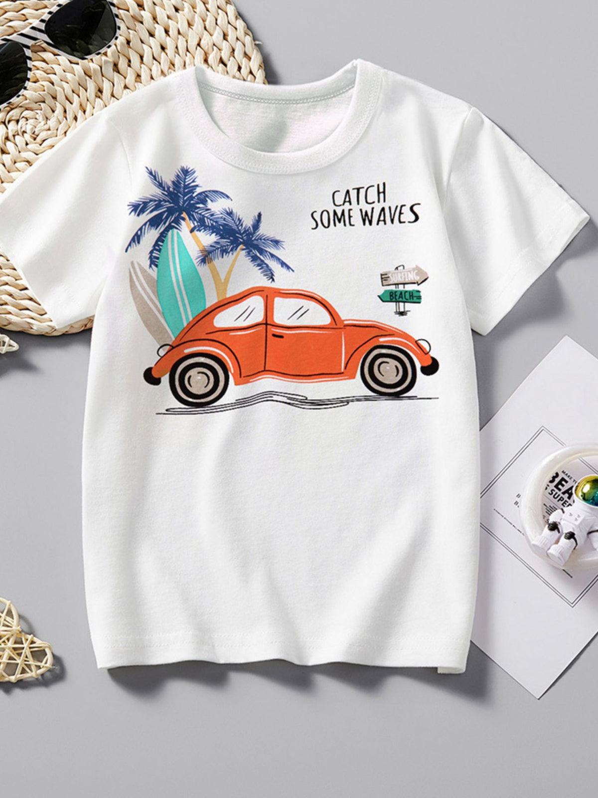 White cotton crew-neck t-shirt with orange car, palm trees, surfboards, and "Catch Some Waves" graphic.
