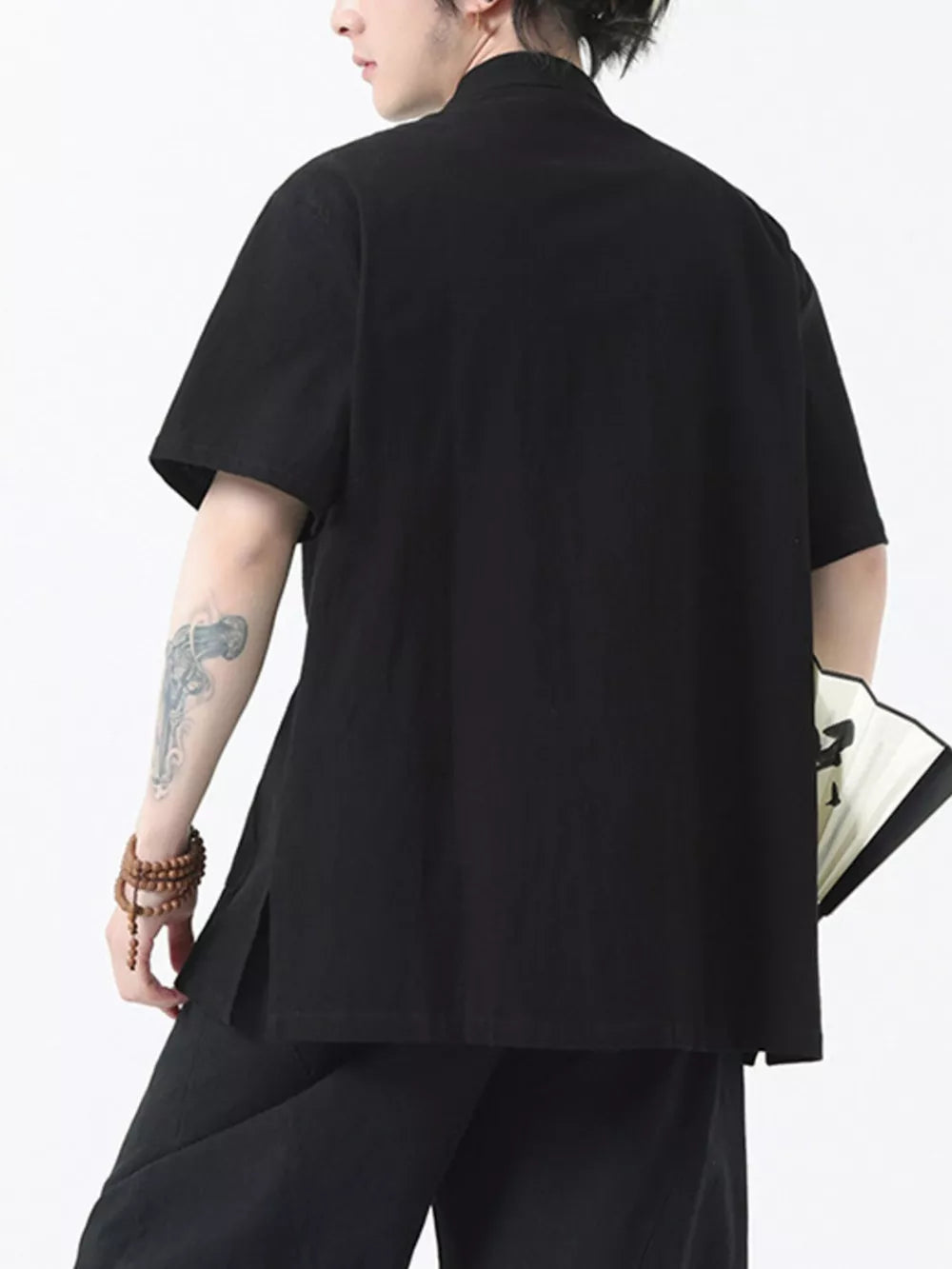 Black short-sleeve cotton shirt with mandarin collar and side slits.