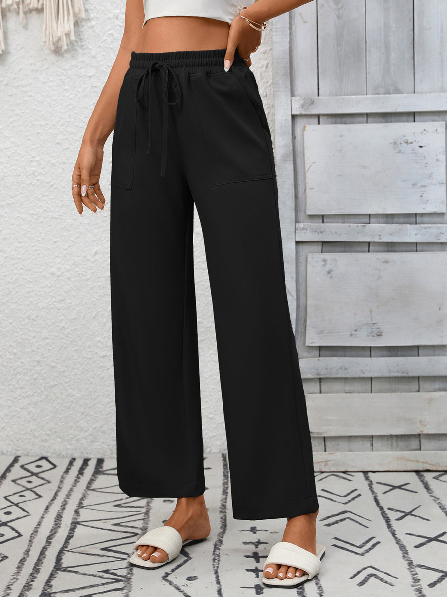 Black drawstring wide-leg pants with pockets and a relaxed fit.