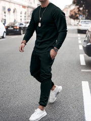 Men's black textured loungewear set with crewneck sweatshirt and drawstring pants.
