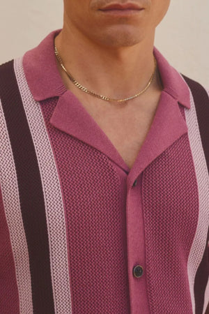 Retro knit polo shirt in red-violet with vertical stripes and a buttoned collar.