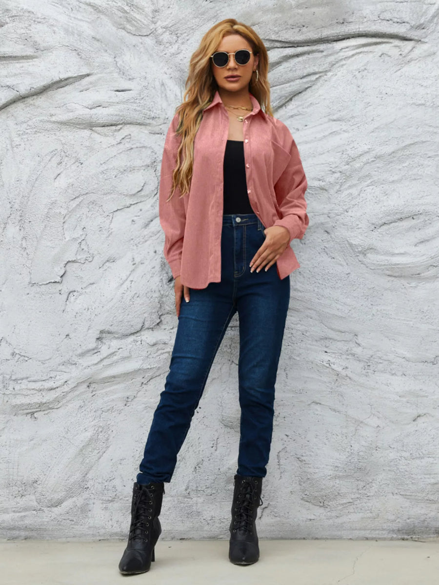 Classic corduroy button-up overshirt in Pinkish, styled open over a black top and jeans.