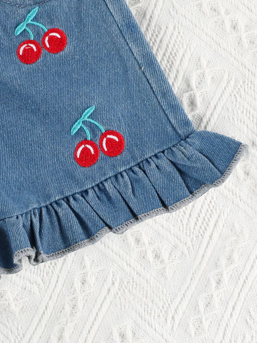 Denim shorts with cherry embroidery and ruffle trim.