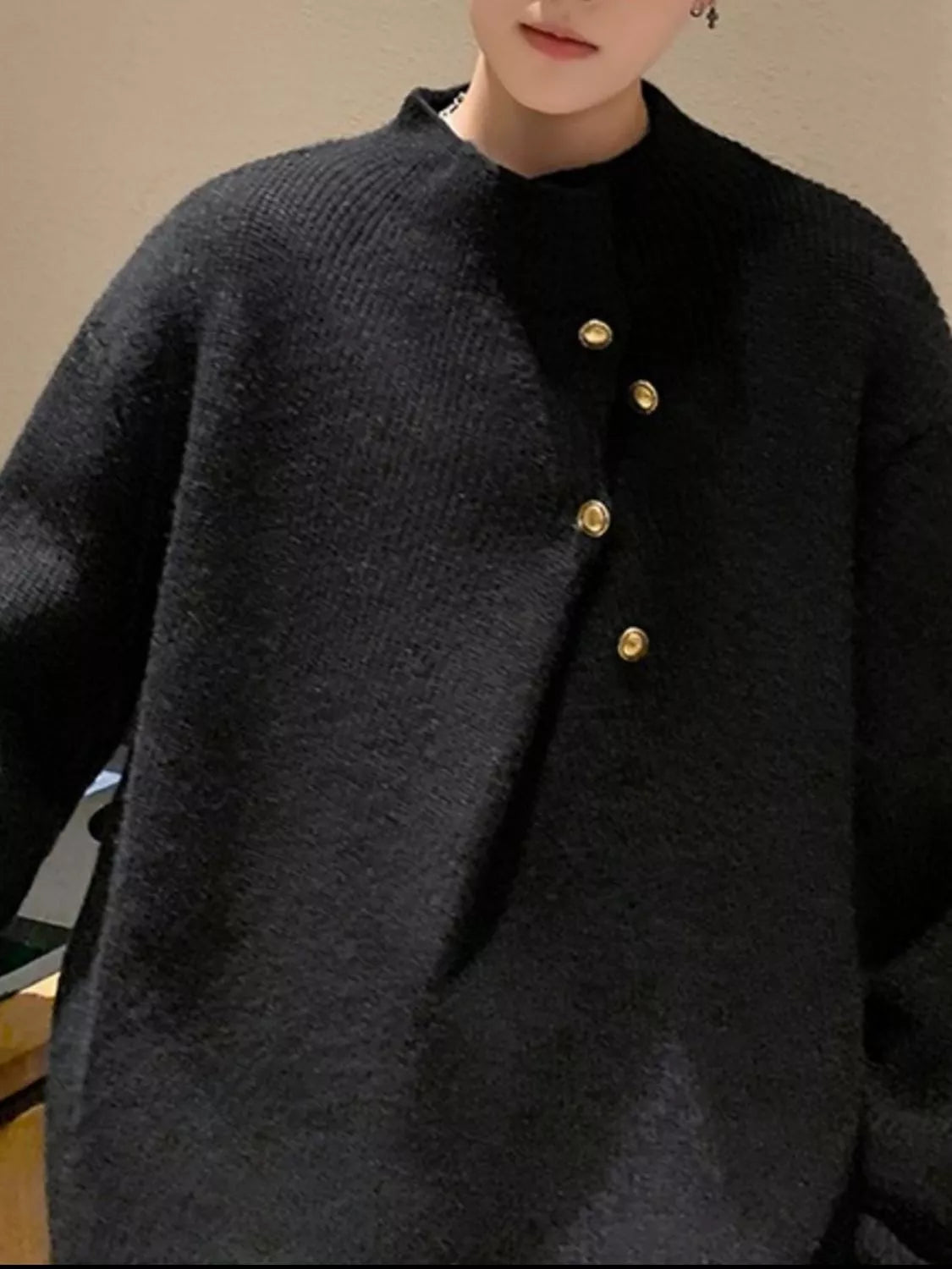 Black knit sweater with gold button accents and a mock neck.