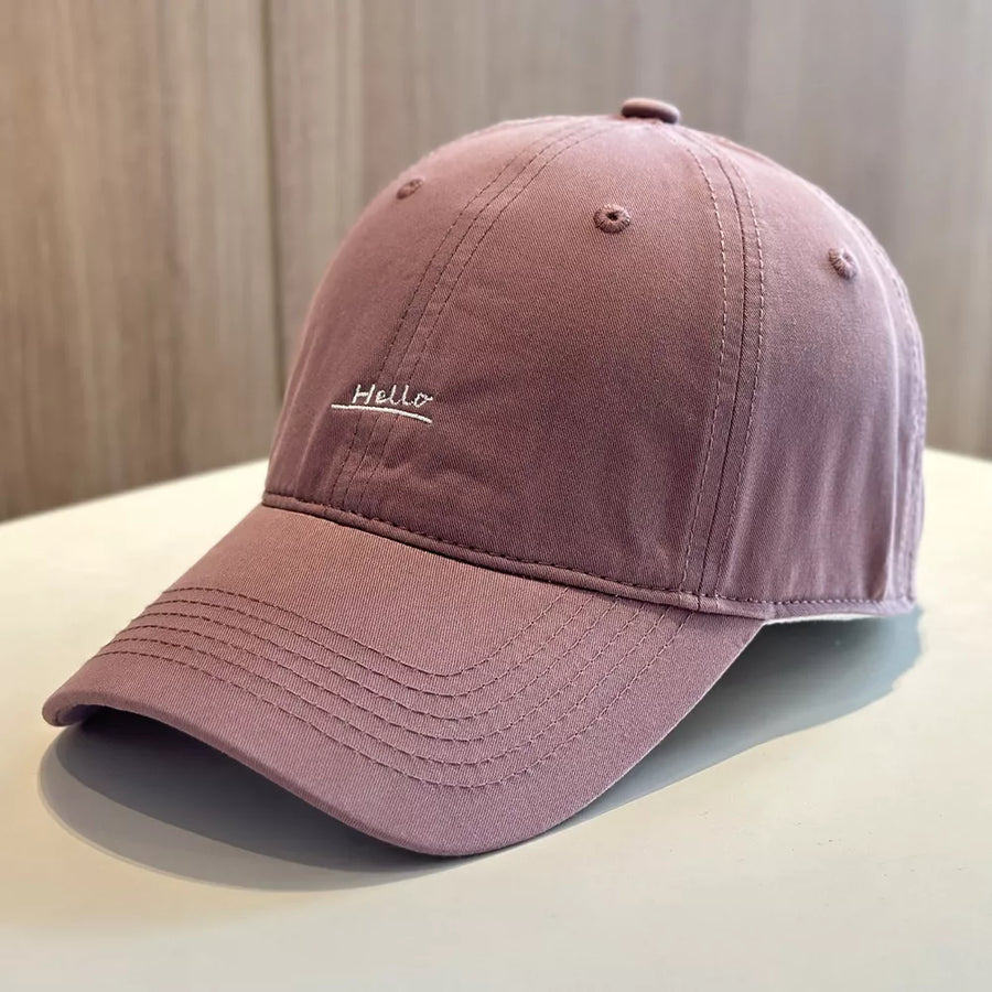 Embroidered baseball cap in purple with "Hello" text detail.