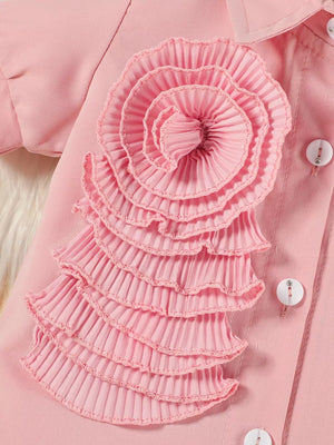 Pink toddler outfit with ruffled floral appliqué and decorative buttons