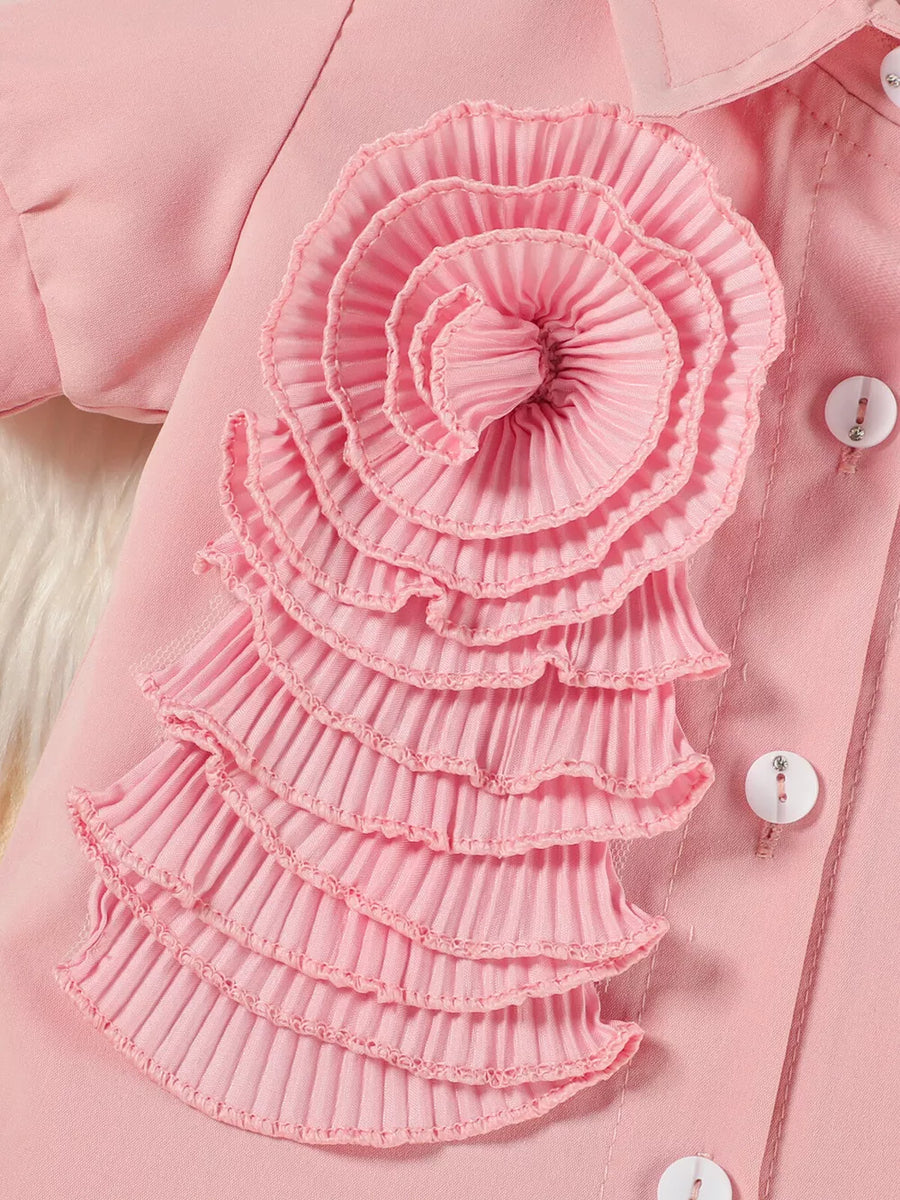 Pink toddler outfit with ruffled floral appliqué and decorative buttons
