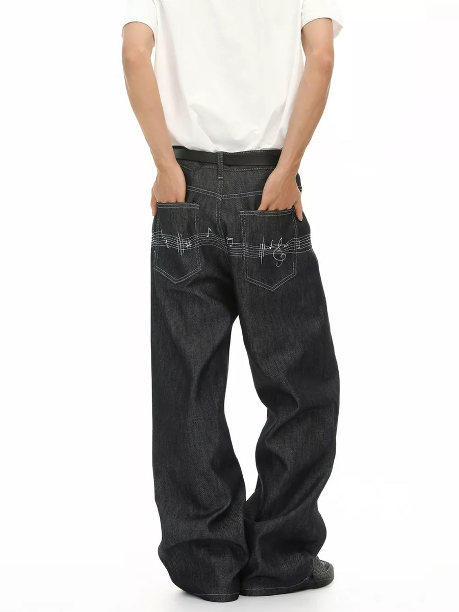 Loose fit dark wash denim jeans with embroidered musical notes on back pockets.