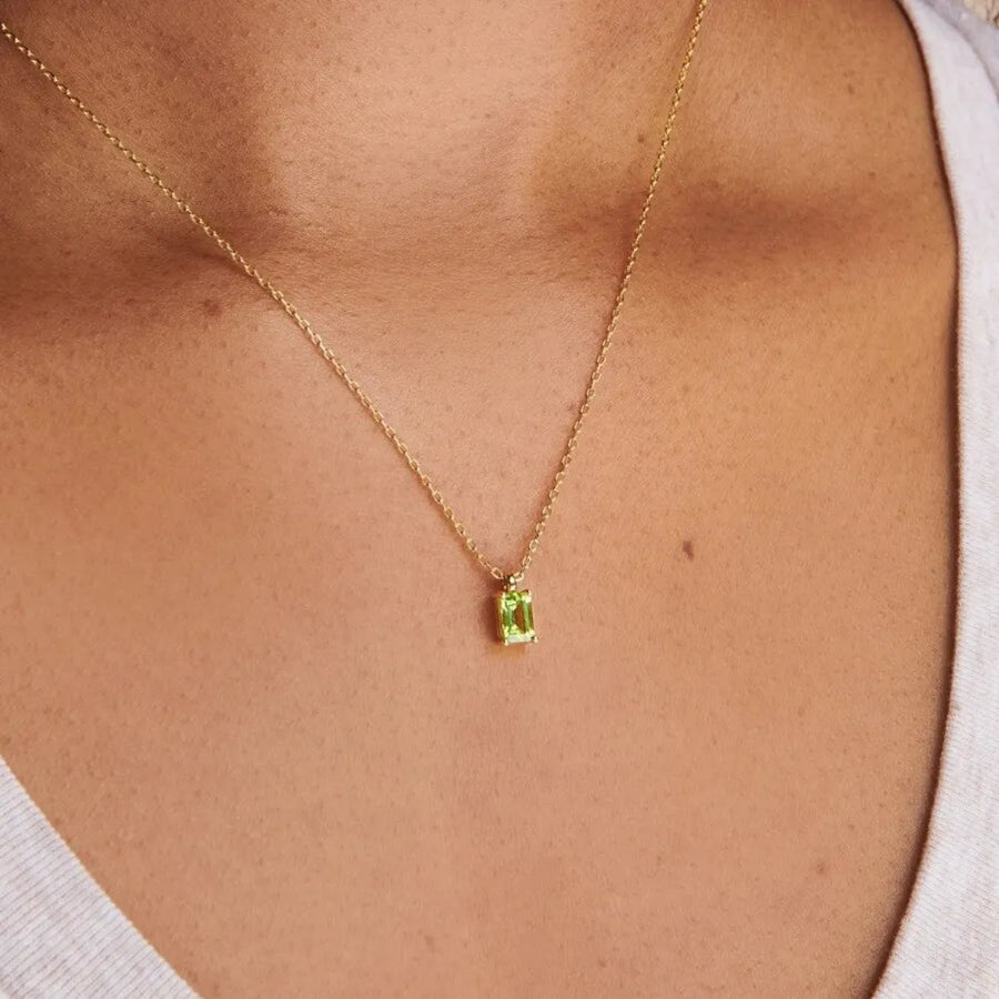 Prism cut gemstone necklace in 18K gold with a single green rectangular gem.