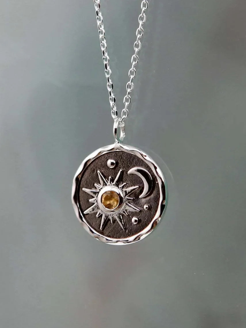 Silver celestial medallion pendant with sun, moon, and zircon detail