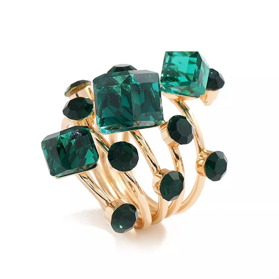Gold-plated ring with dark green square and round crystals in a multi-layered design.
