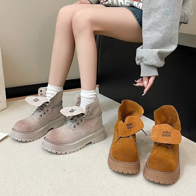 Fold-over suede platform boots in light gray and pumpkin with branding details.