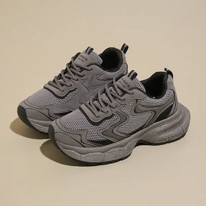 Dark gray mesh chunky trainers with black accents and a thick sole.