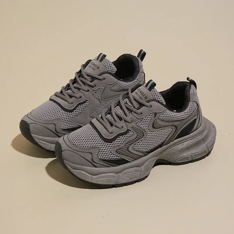 Dark gray mesh chunky trainers with black accents and a thick sole.