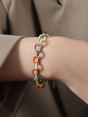 Gold chain bracelet with colorful enamel links and gold accents.