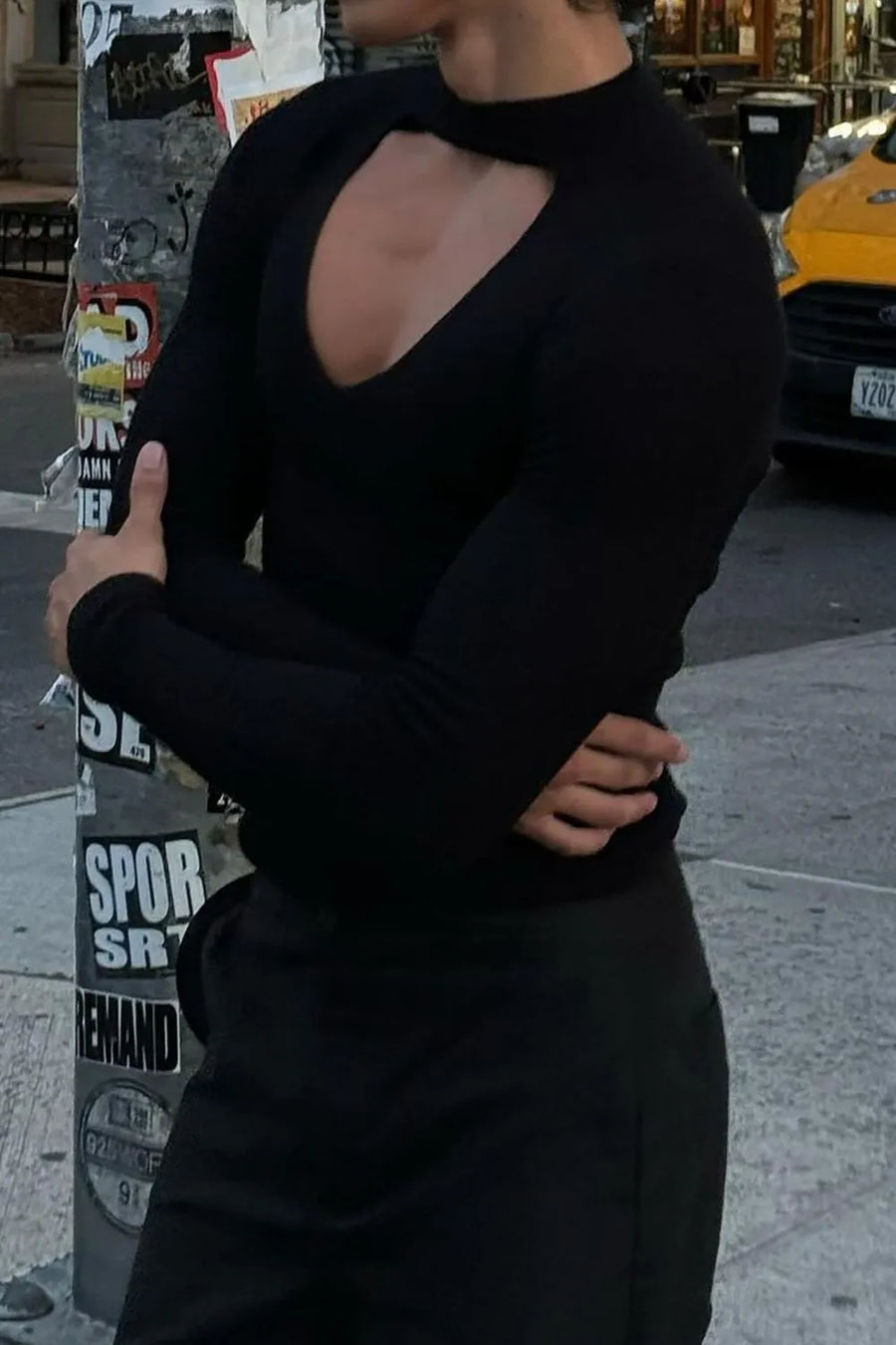 Black ribbed knit top with a long sleeve and a daring keyhole cutout neckline.