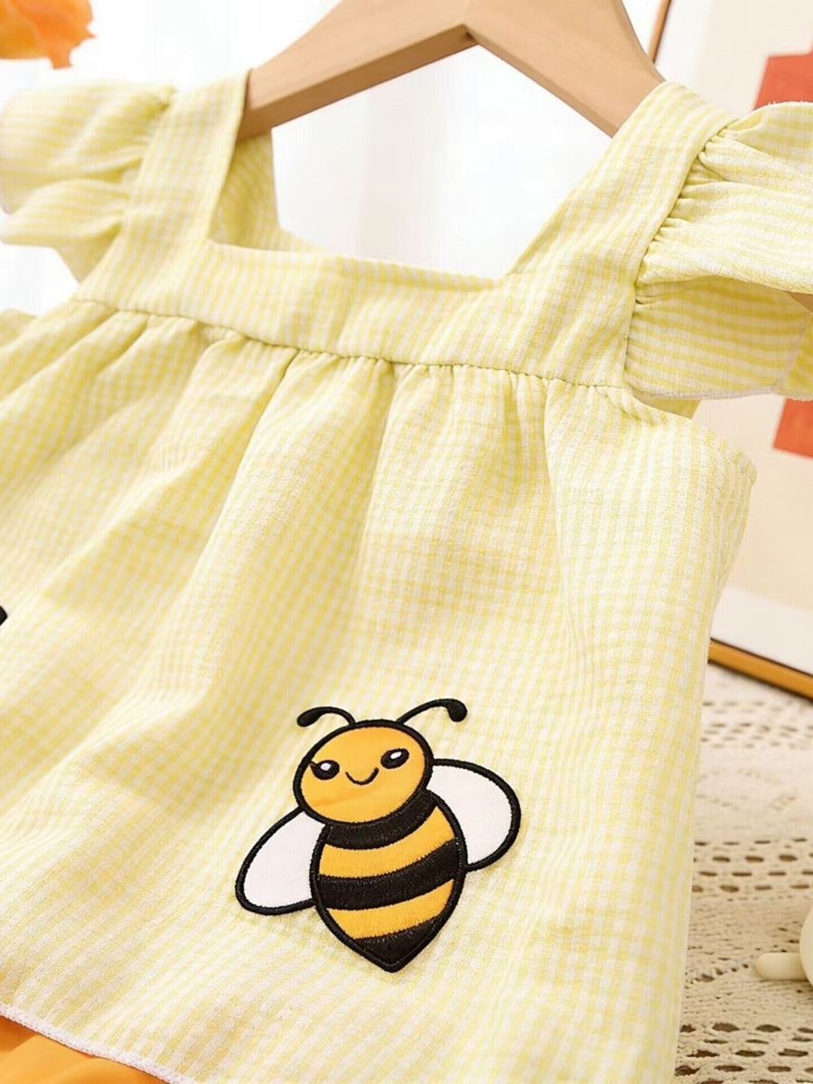 Yellow gingham baby top with ruffled sleeves and bee embroidery.