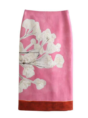 Vibrant floral print pencil skirt in pink with abstract white flowers and a rust hem.