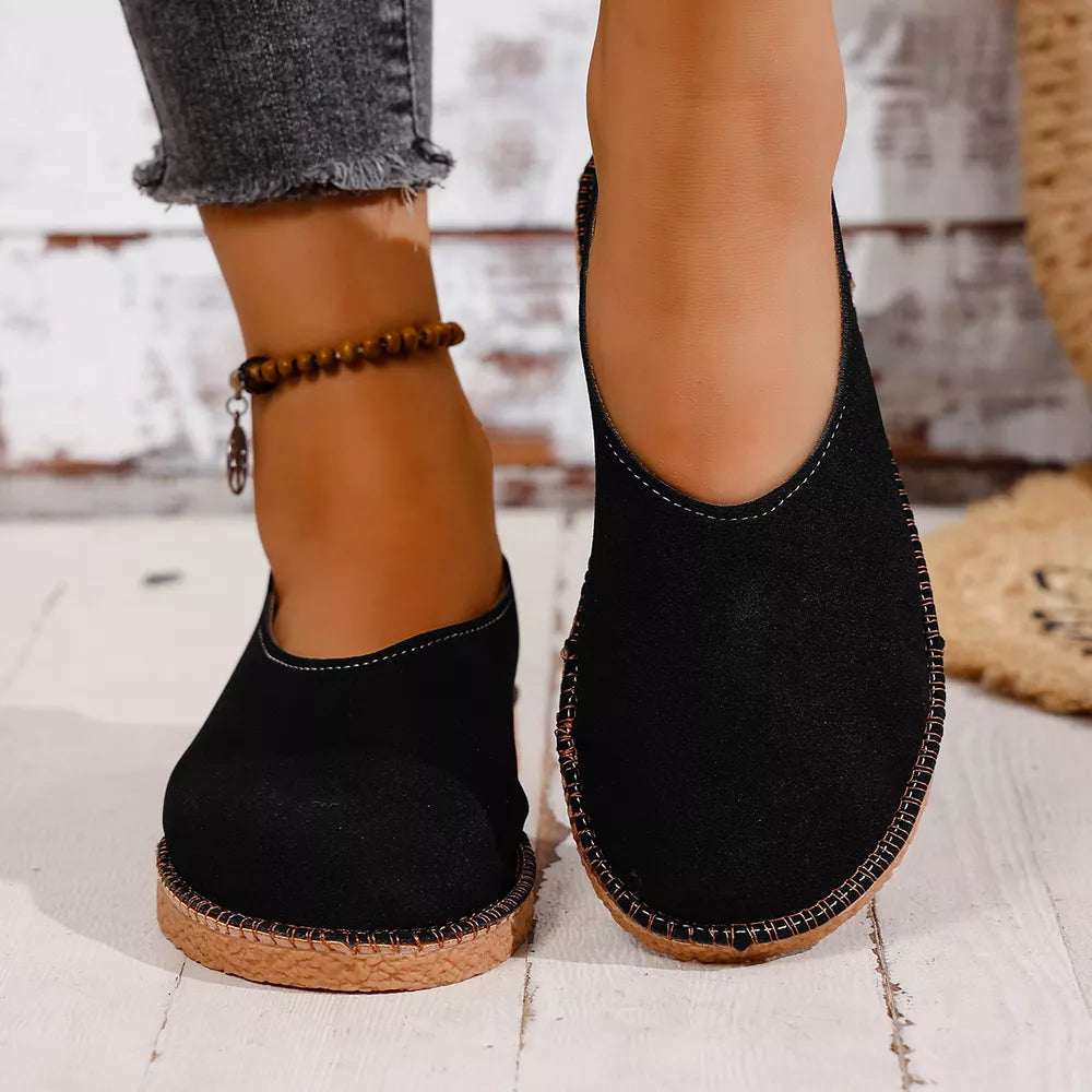 Black round toe comfort flats with contrast stitching and a textured sole.