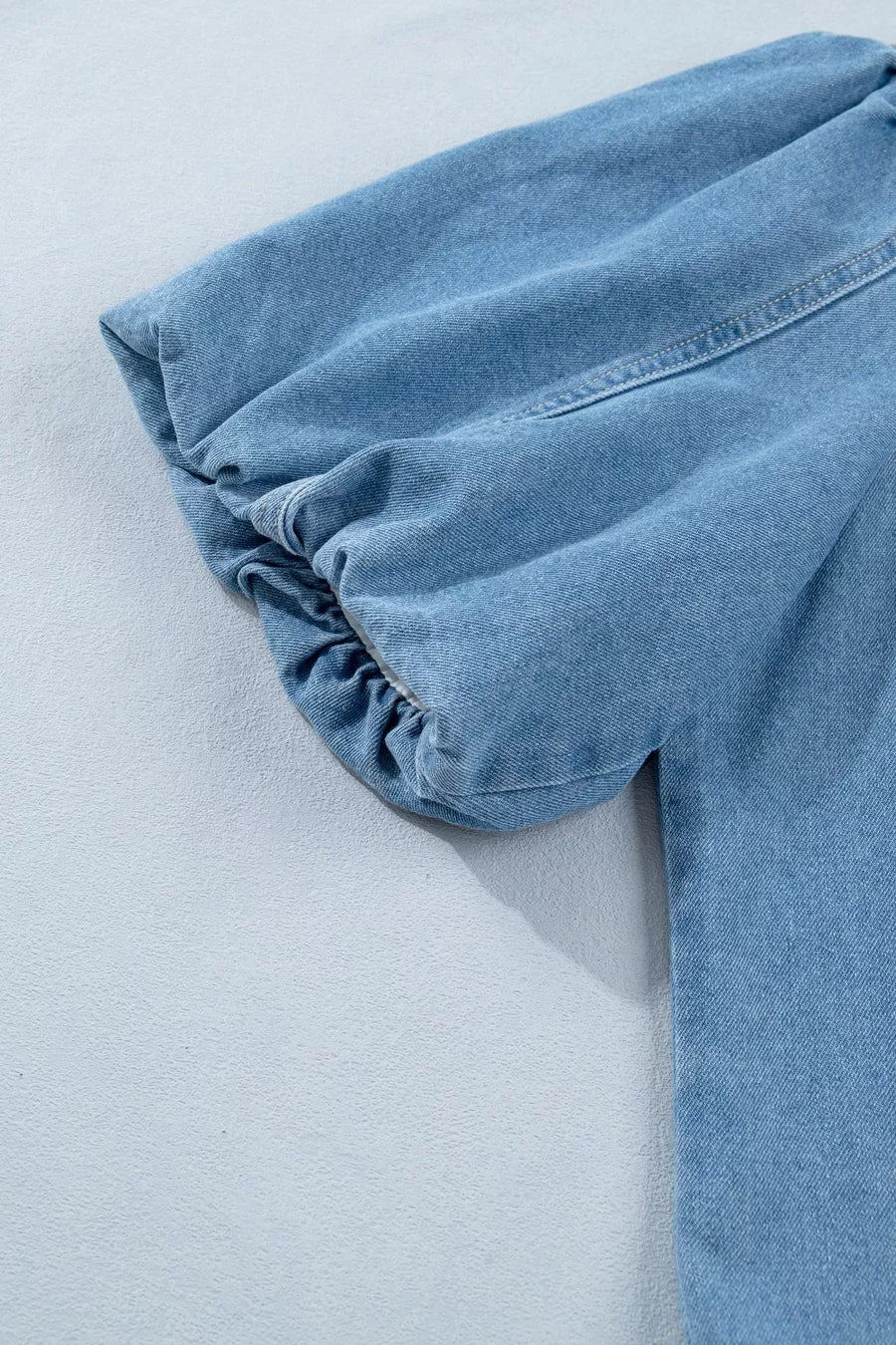 Light blue denim dress with voluminous puff sleeves and elasticated cuffs.