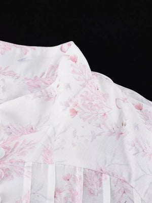 White floral print blouse with button detail and pleated front.