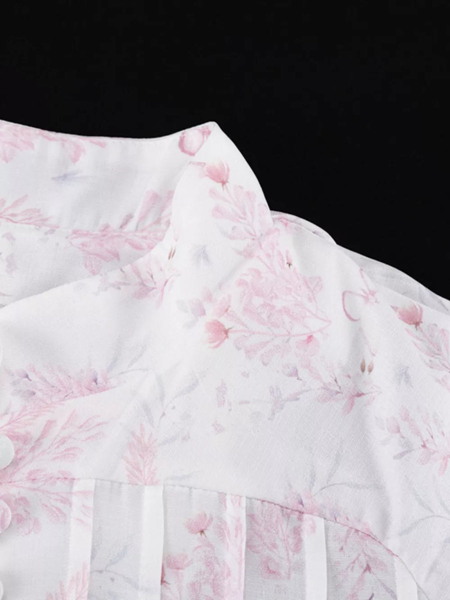 White floral print blouse with button detail and pleated front.