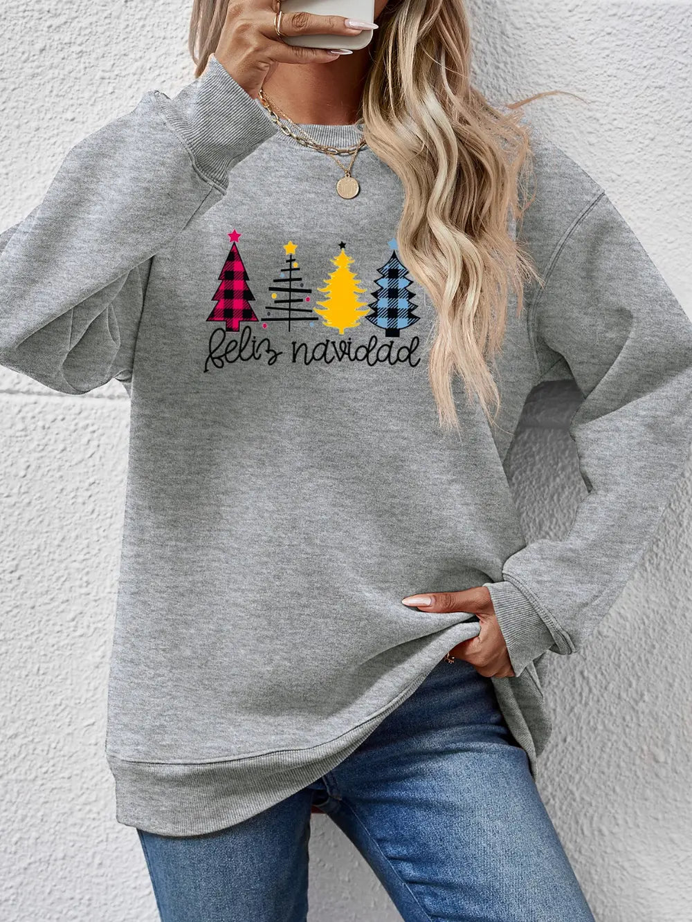 Feliz Navidad graphic crewneck sweatshirt in gray with festive Christmas trees and plaid details.