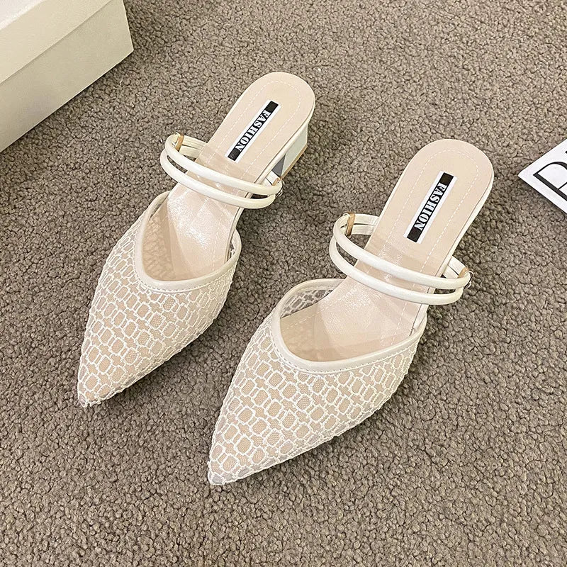 Ivory lace-overlay slingback pointed-toe mules with double strap detail.