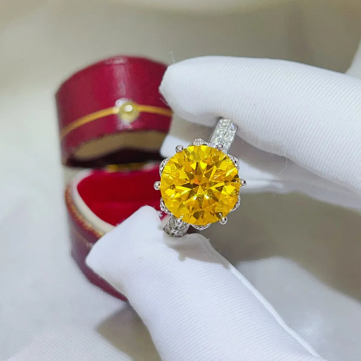 Yellow moissanite solitaire ring with diamond-accented band in a jewelry box.