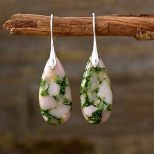 Marbled teardrop earrings with pink and green gemstone inlay and silver hooks.