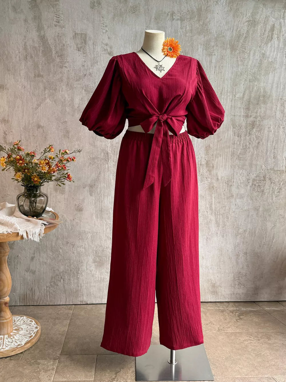 Deep red textured tie-front crop top with balloon sleeves and wide-leg pants set