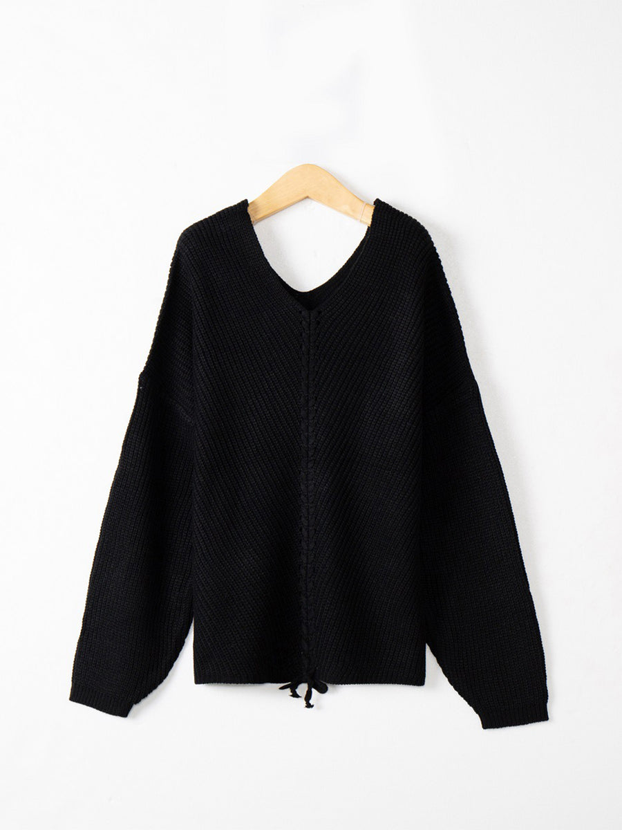 Black knit sweater with V-neck and lace-up detail at hem