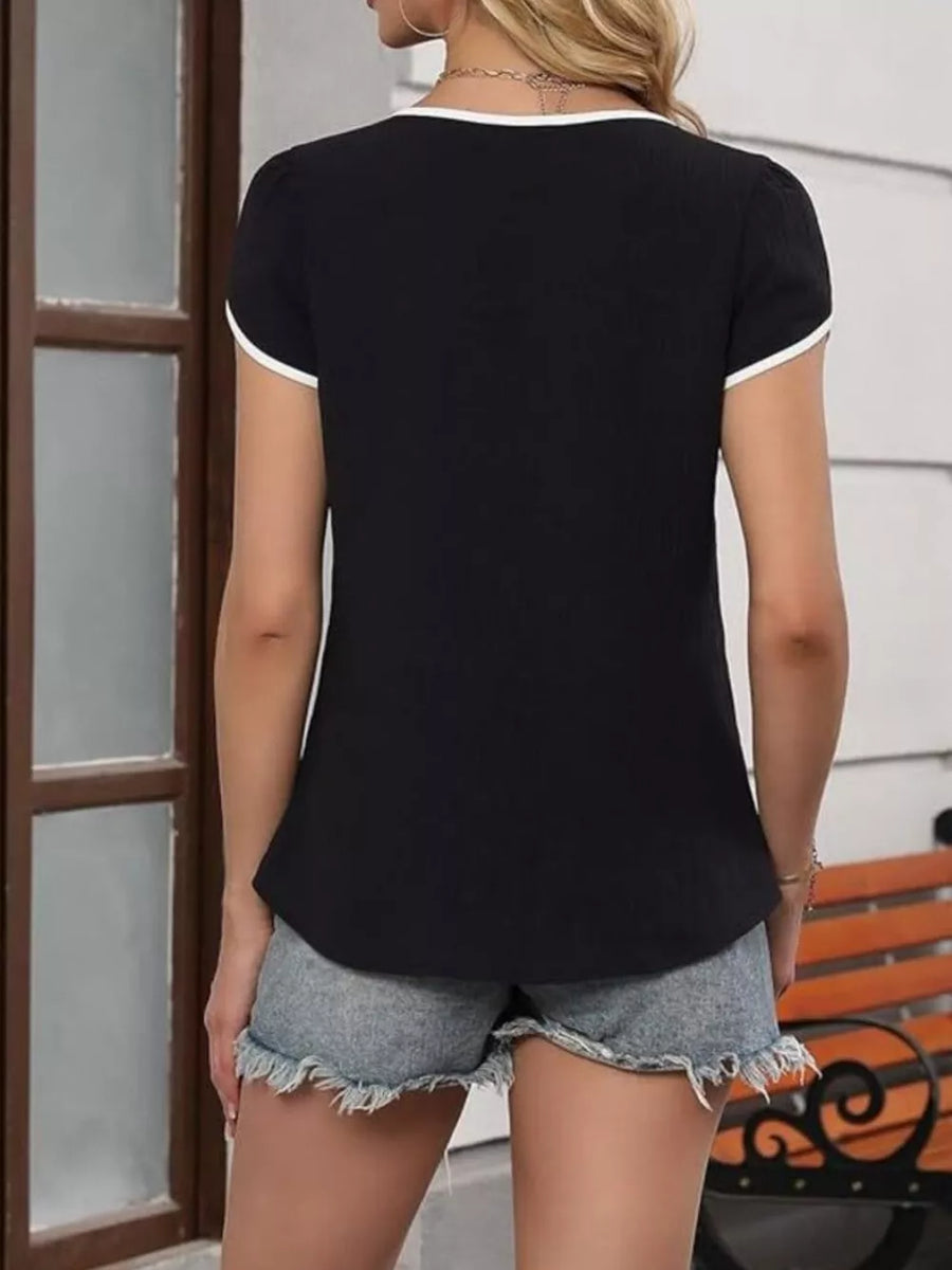 Black blouse with white trim, petal sleeves, and V-neck.