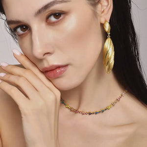 Textured gold leaf drop earrings with a colorful floral choker necklace.