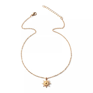 Gold sunburst pendant necklace with lace trim detail on a delicate chain.