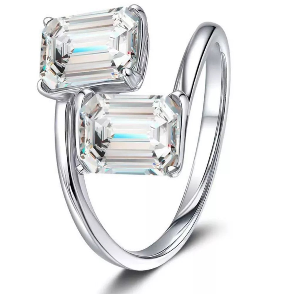Emerald-cut moissanite bypass ring in silver with two clear stones.