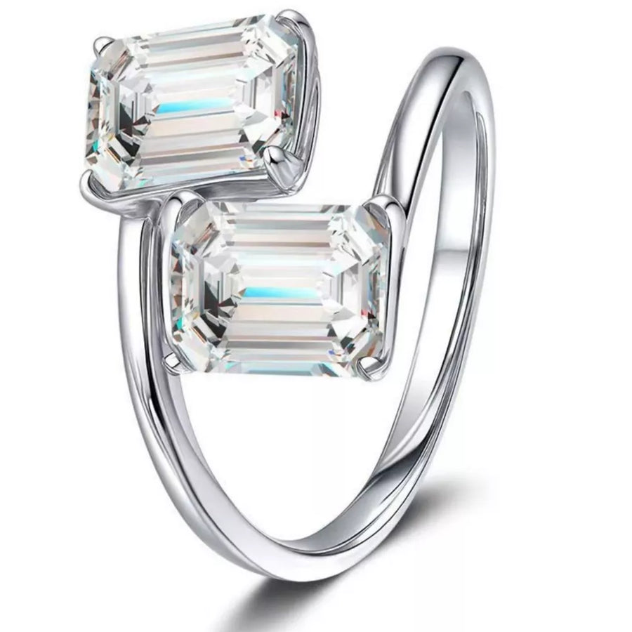 Emerald-cut moissanite bypass ring in silver with two clear stones.