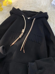 Black drawstring hoodie with embossed text and contrast drawstrings.