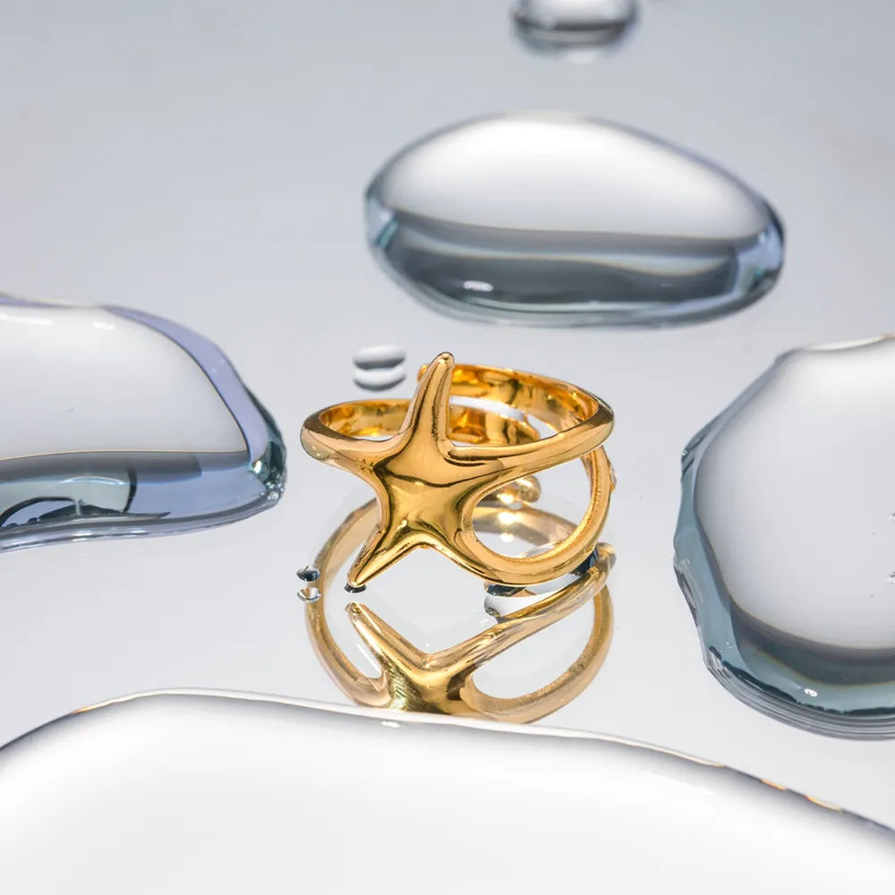 Gold starfish silhouette adjustable ring with open band detail.