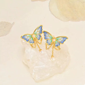 18K gold-plated butterfly earrings in cerulean with pearl drops and delicate chains.