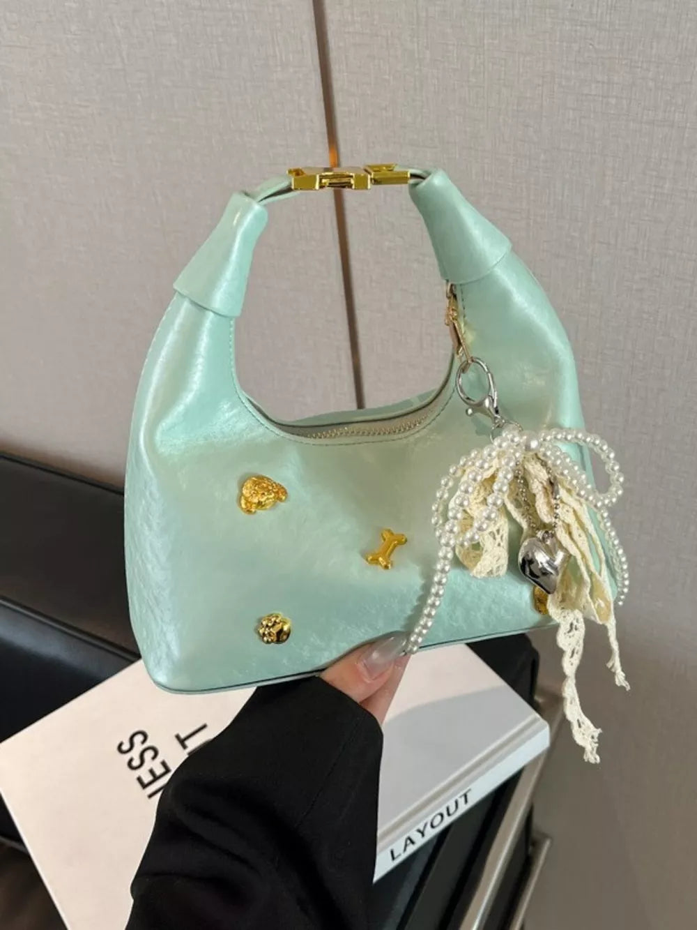 Pastel yellow hobo bag with gold accents and pearl charm