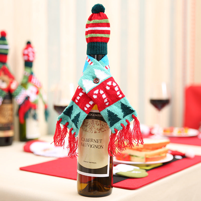 Holiday knit bottle cosy with candy cane and Christmas tree pattern, red and green striped hat with pompom.