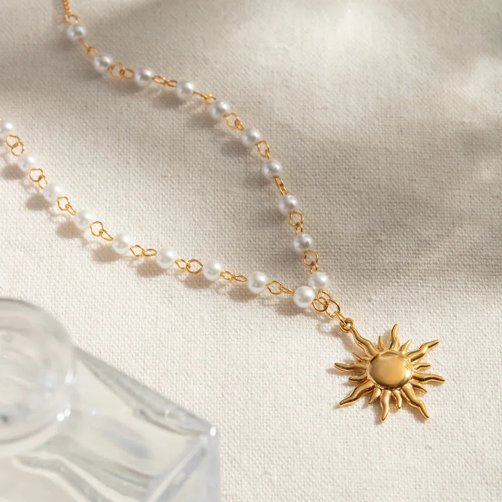 Gold celestial sun pendant necklace with pearl and chain detail