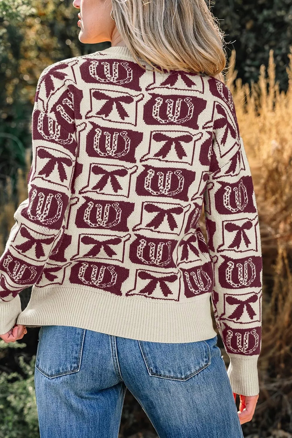 burgundy pullover sweater featuring ribbed cuffs and bow and horseshoe motif