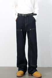 Dark wash denim carpenter pants with a wide, relaxed fit and contrast stitching.