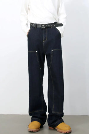 Dark wash denim carpenter pants with a wide, relaxed fit and contrast stitching.