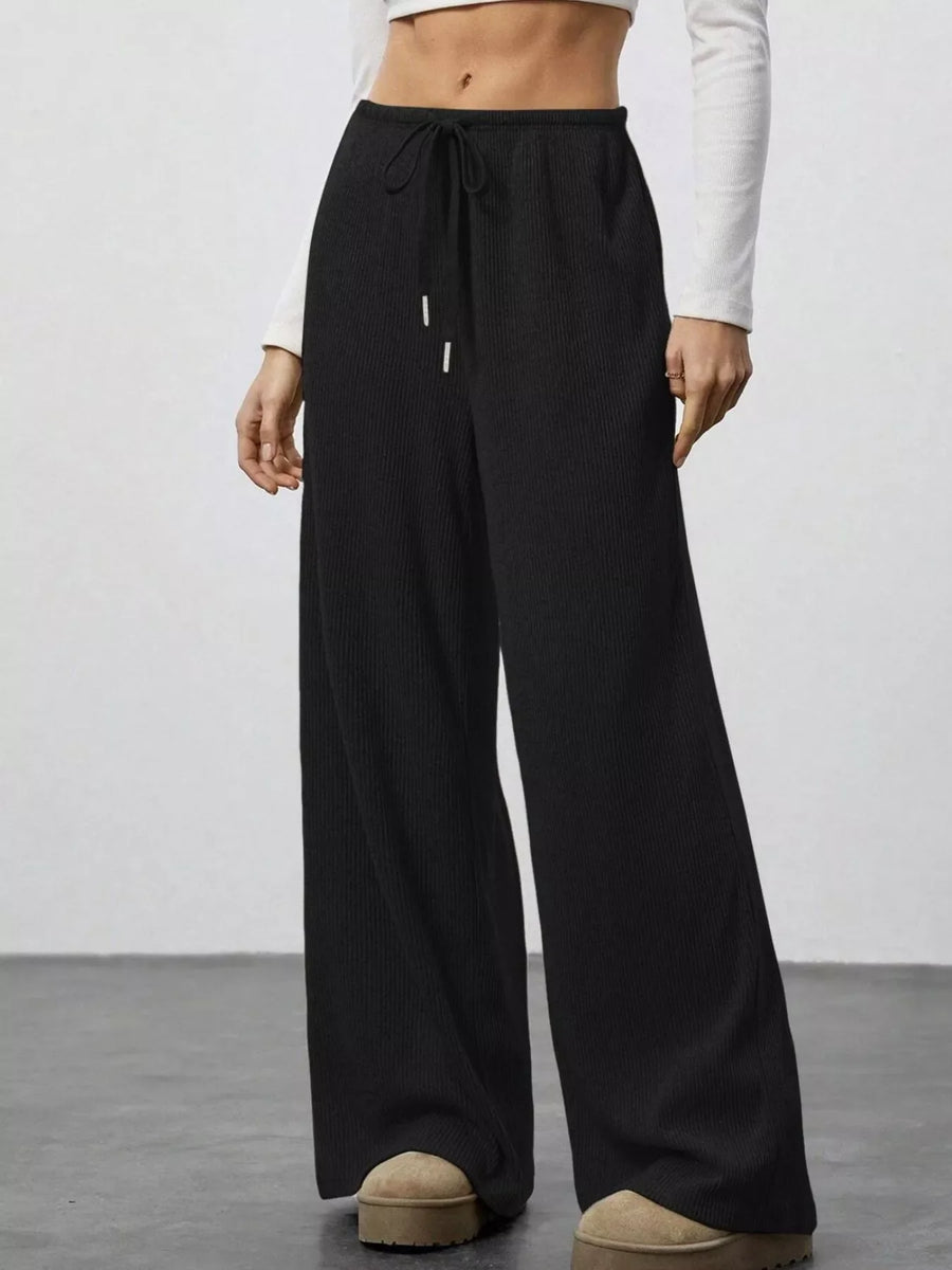 Black ribbed wide-leg pants with drawstring waist and white tips.