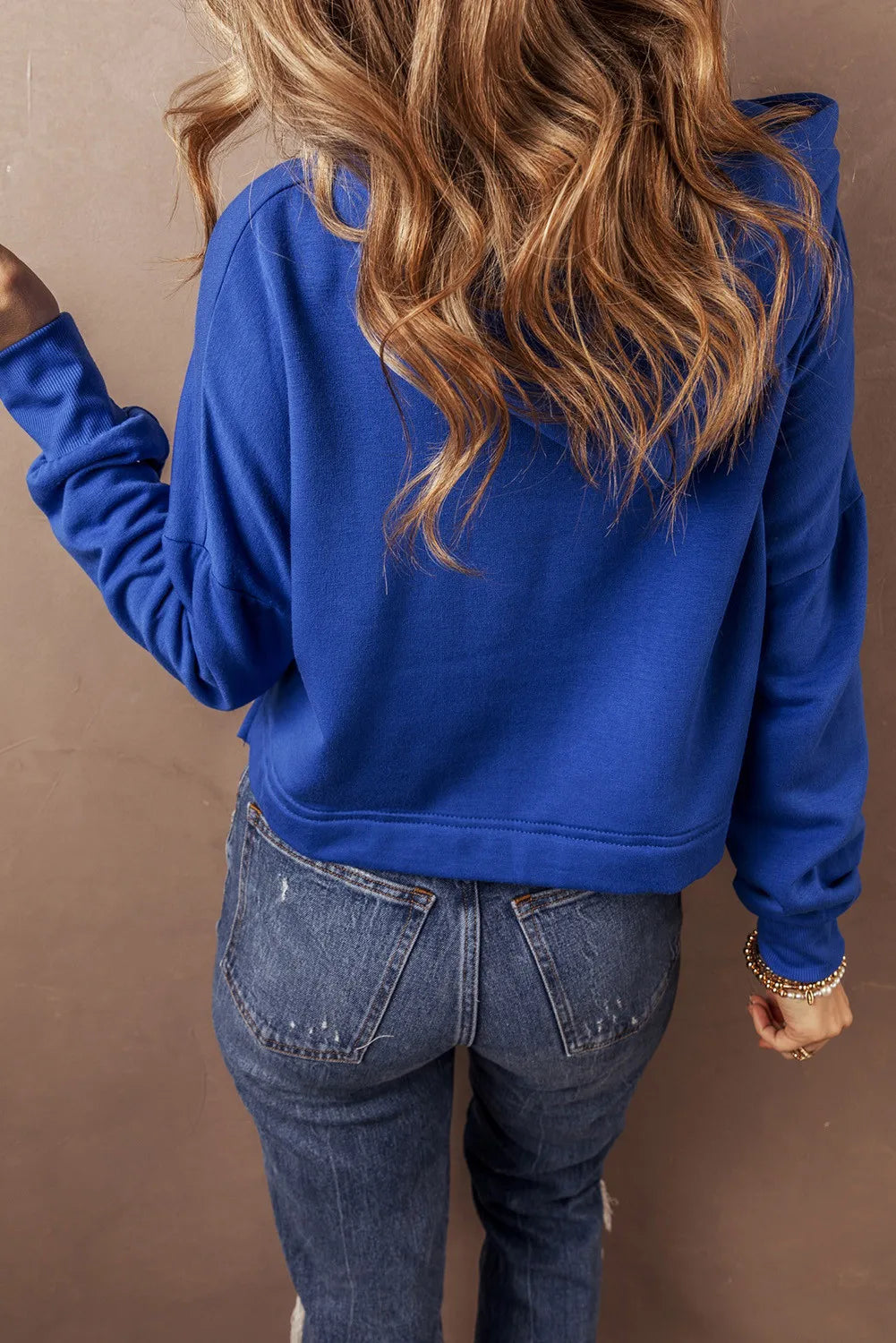 Royal blue cropped hoodie with adjustable hood and glitter detail.