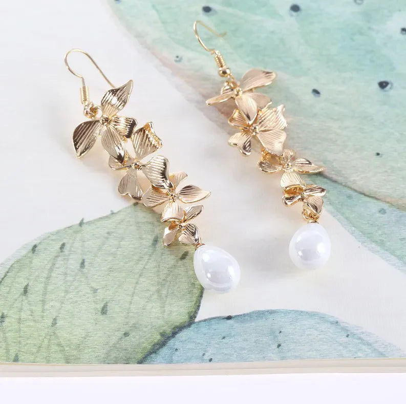 Gold cascading flower drop earrings with white pearls.
