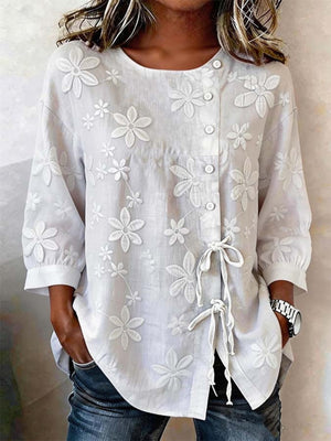 White embroidered floral button-down shirt with 3/4 sleeves and tie detail
